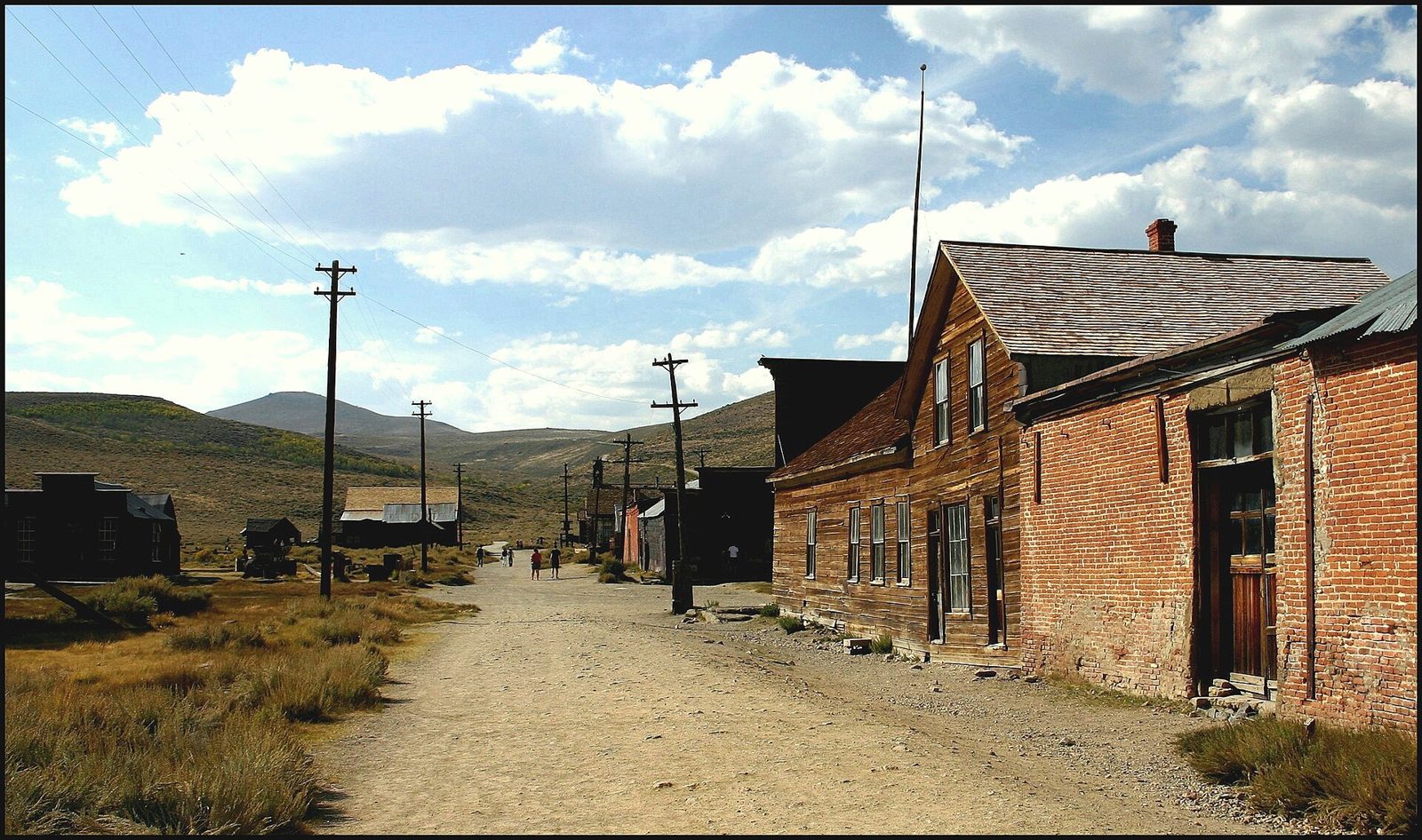 Weathered wooden buildings of a ghost town on a dry hillside