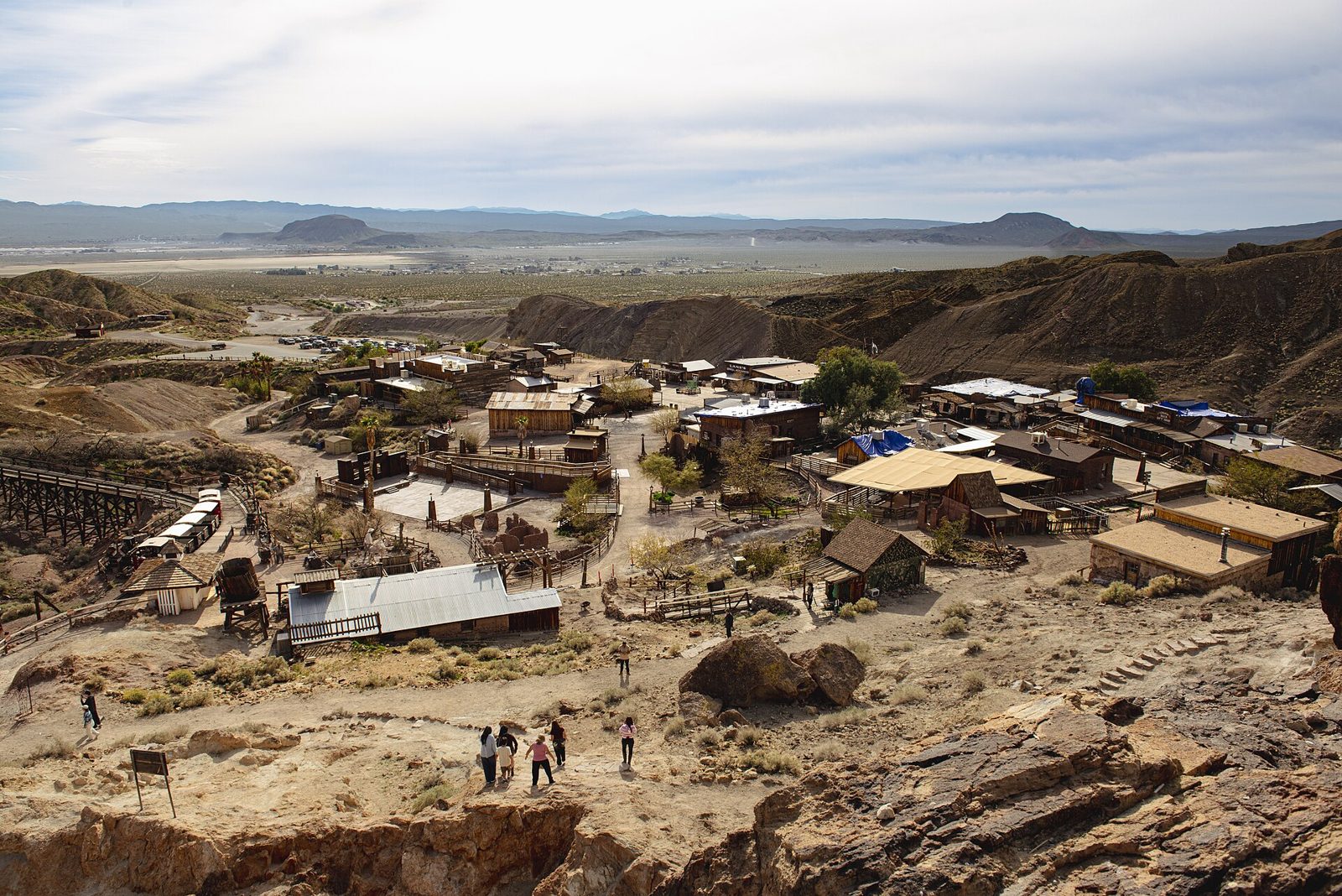 Desert ghost town buildings below striped hills