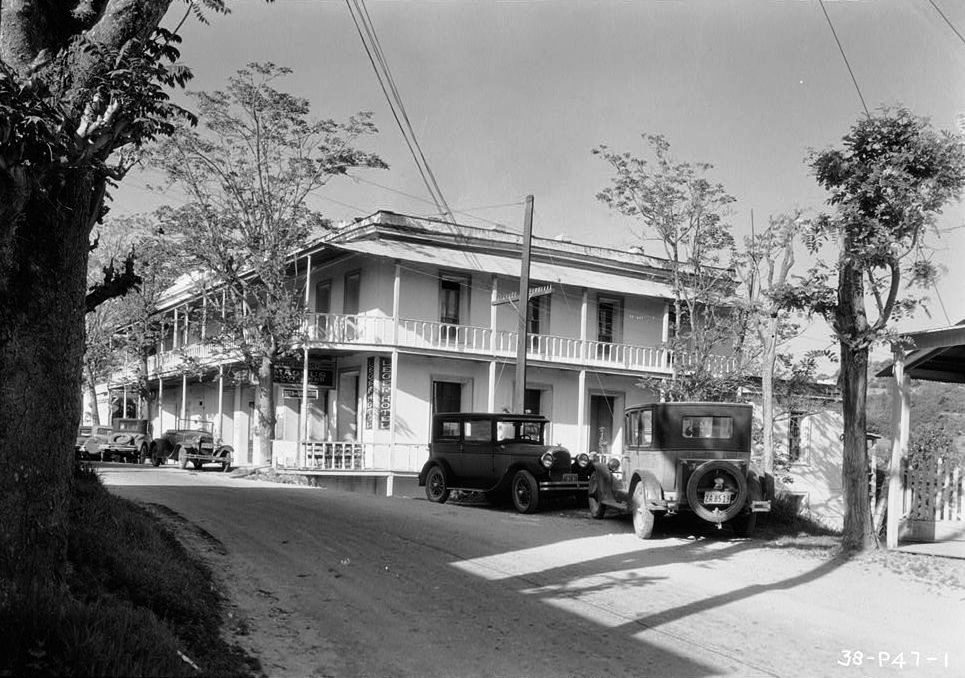 Two-story stone hotel with a balcony on a town street