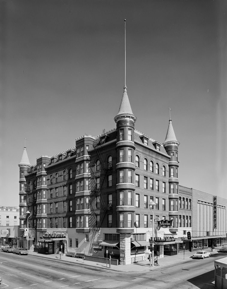 Six-story red brick building with round corner turrets