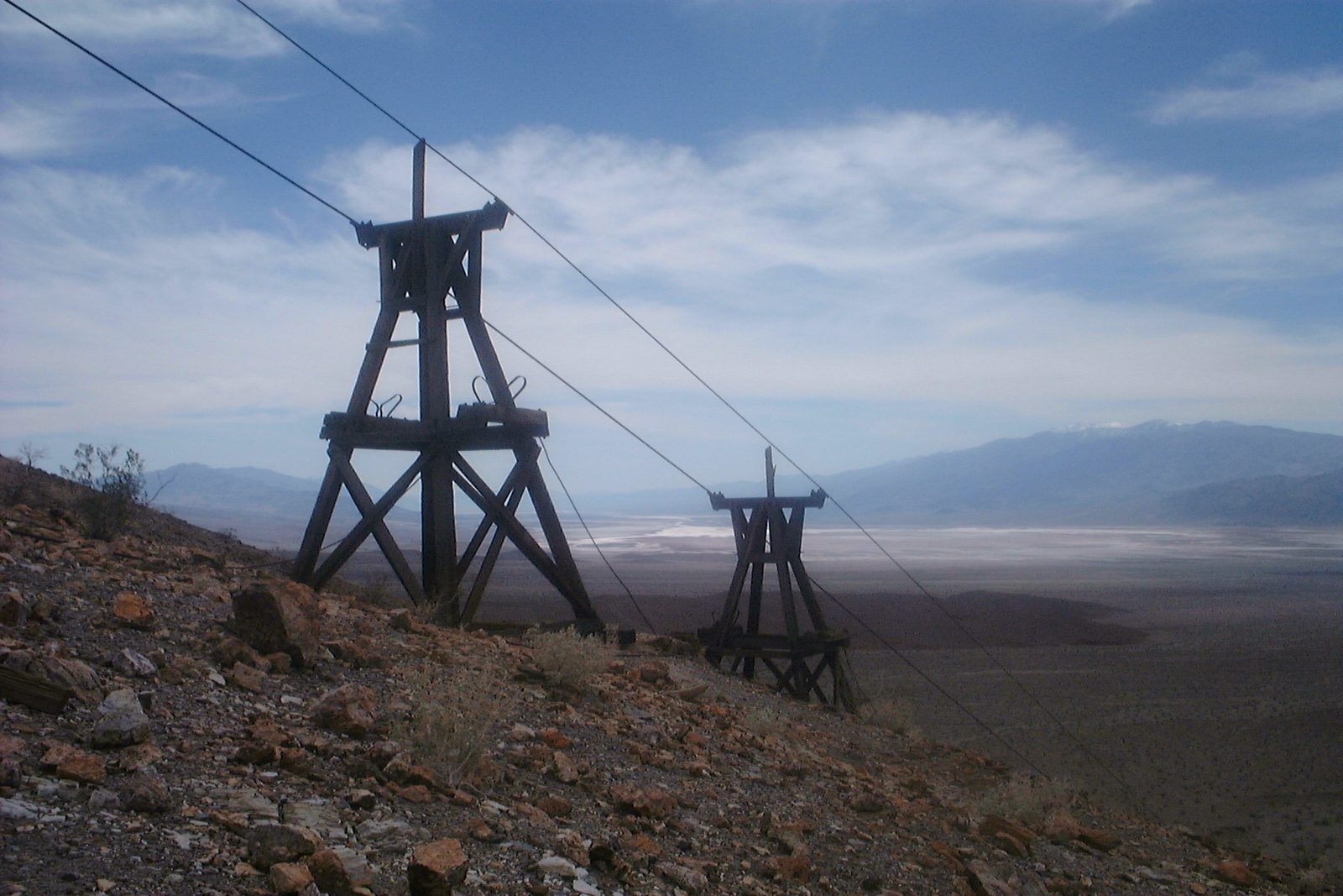 Weathered wooden tramway tower on a bare desert slope