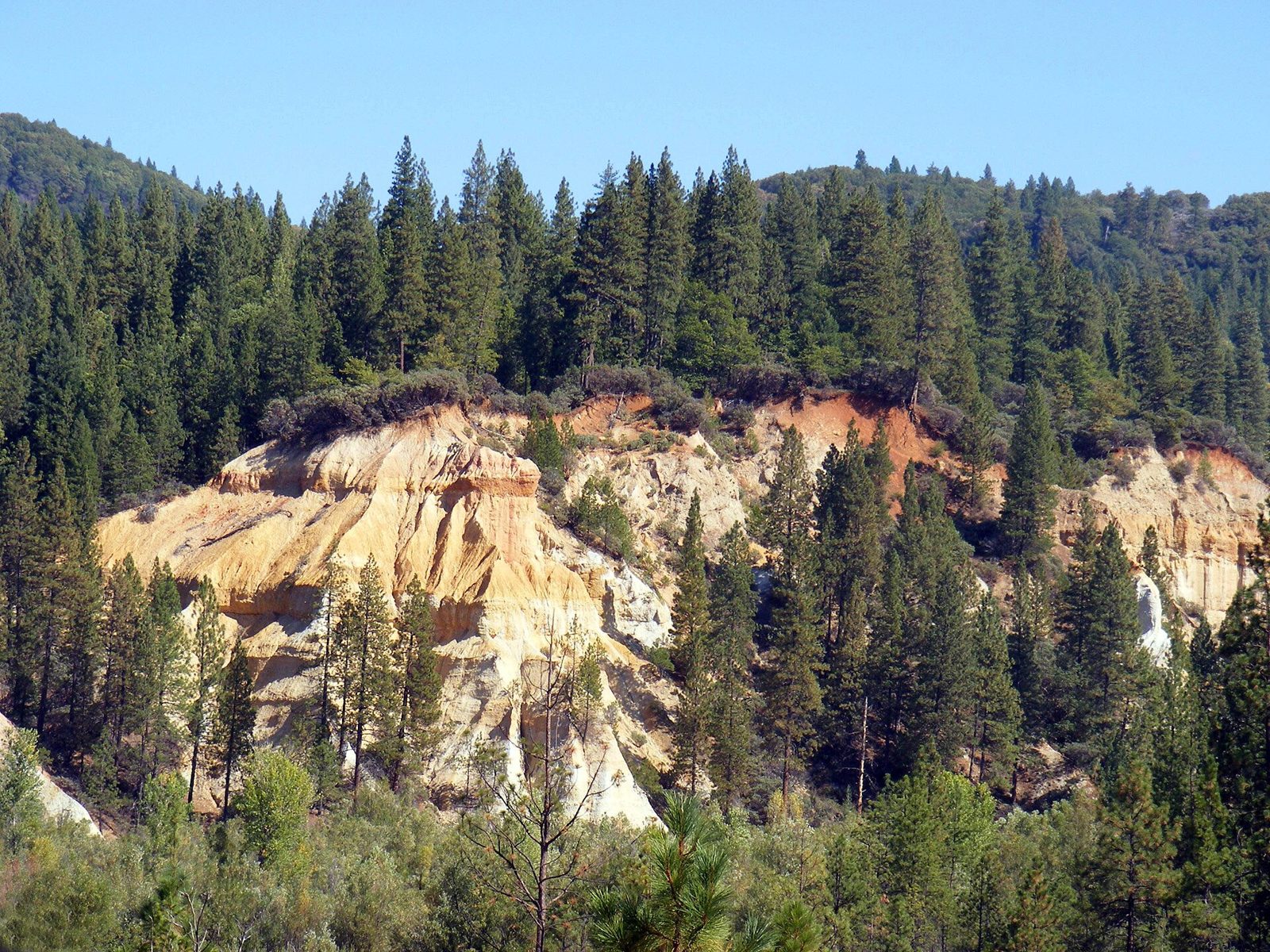 Eroded pink and white cliffs of a huge hydraulic mining pit