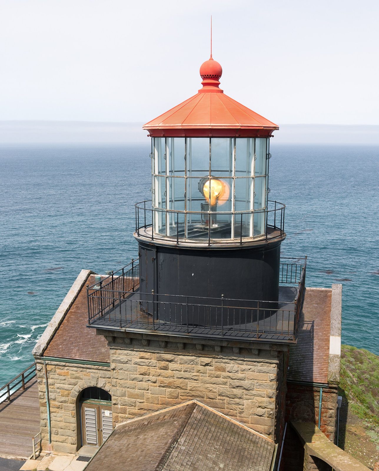 Stone lighthouse lantern room atop a rocky headland