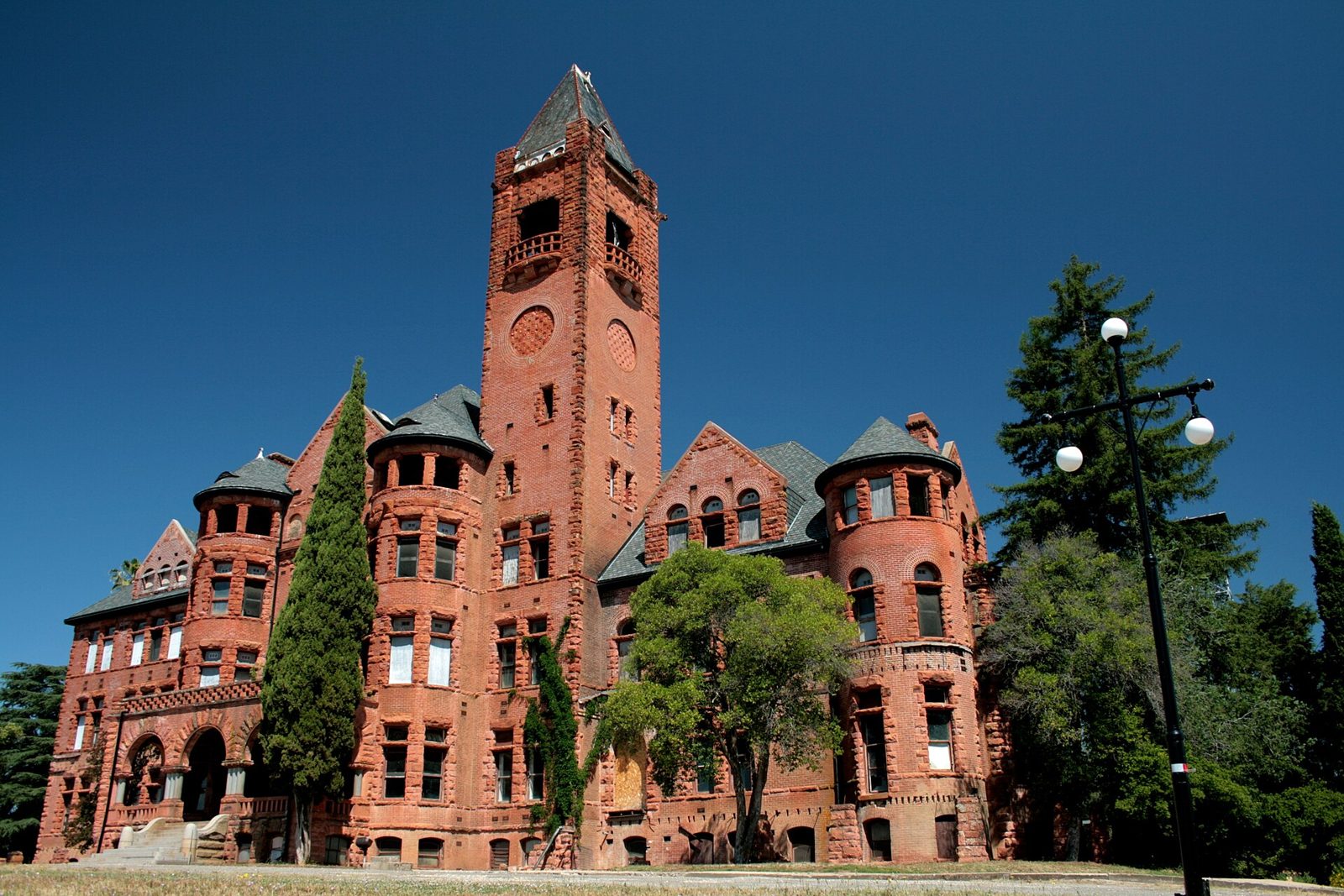 Massive red brick Romanesque castle-like building on a hill